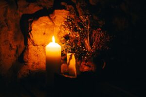 Weiße Lilie und Kerze auf einem Holztisch als Symbol für ein engagiertes Team