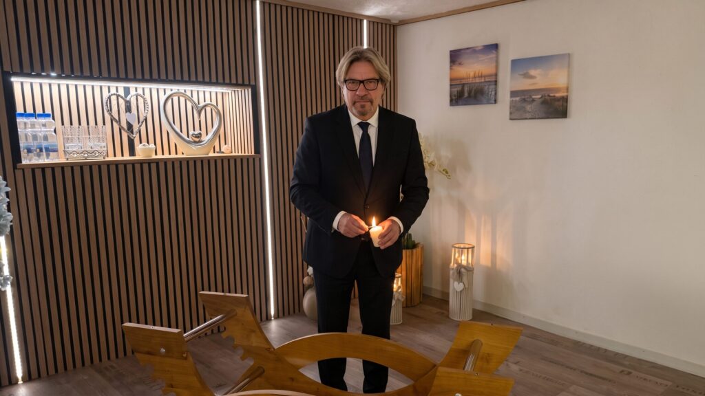Cornelius entzündet eine Kerze im Abschiedsraum von Bestattungen Zeitlos.